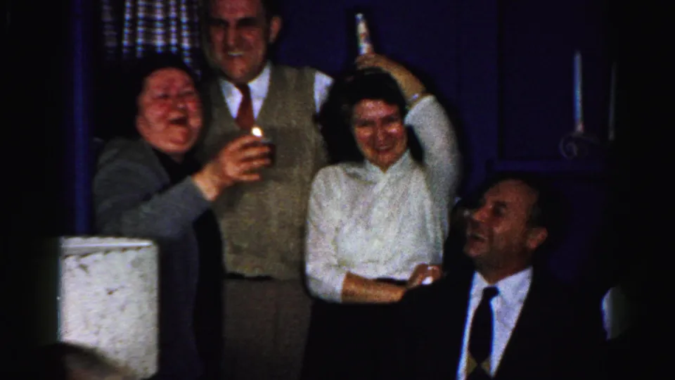 A 1950s Albany party frame shows adults laughing, a woman raising a bottle, and a seated man looking toward the group.