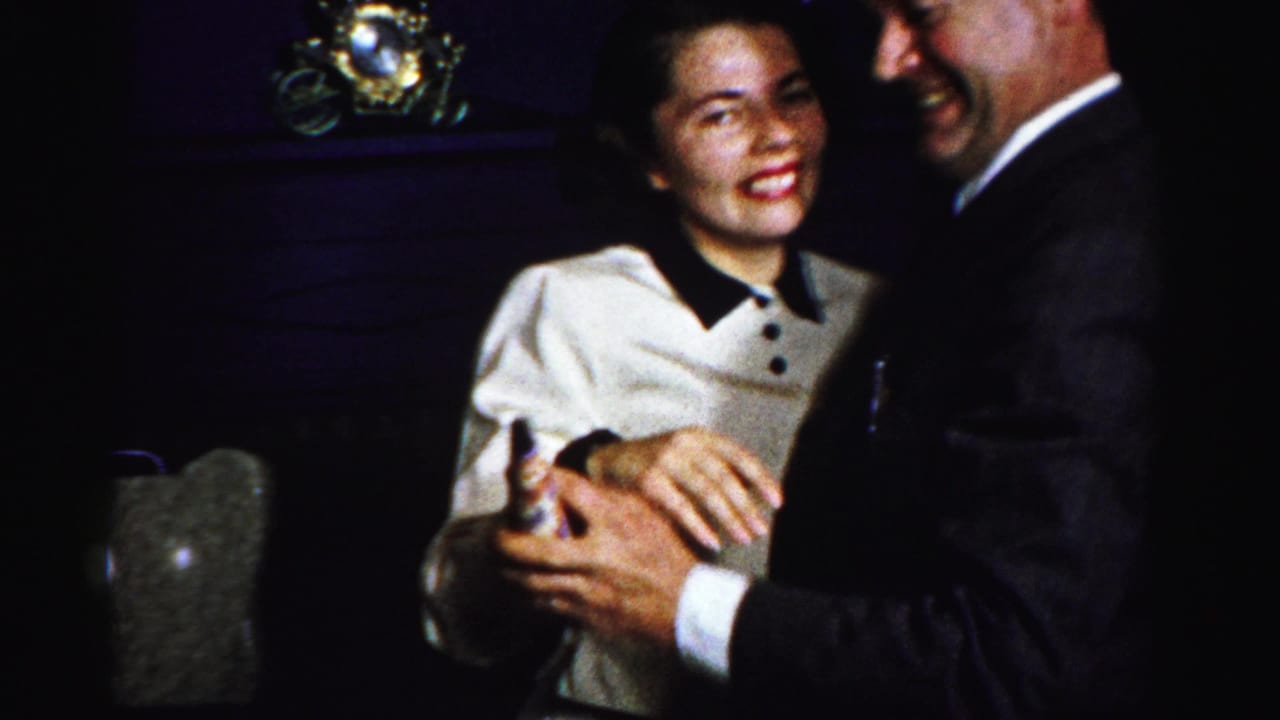 In Albany home-movie footage from the 1950s, a young woman in a white sweater smiles while dancing with a man in a dark suit.
