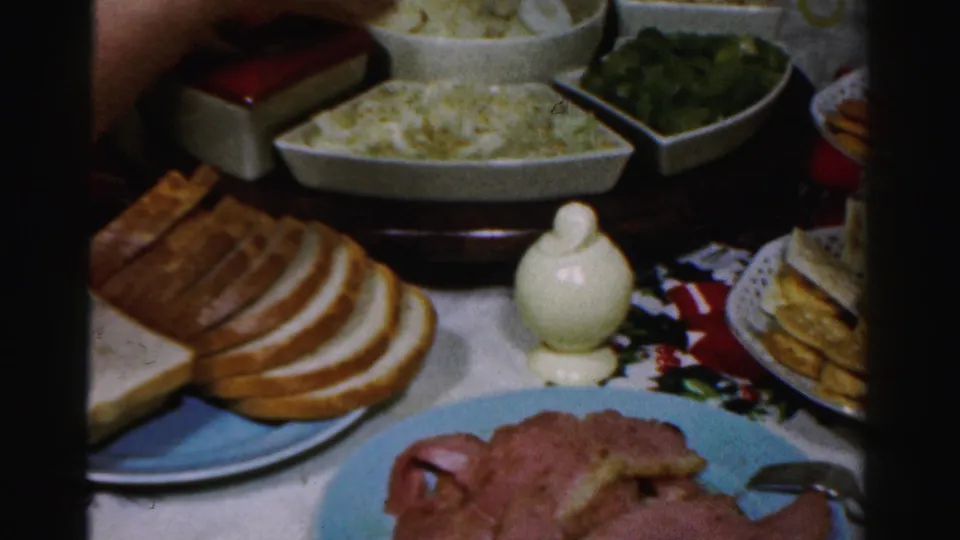 Albany 1956 holiday table frame with bread slices, sliced ham, coleslaw, green beans, crackers, cheese, and serving bowls.