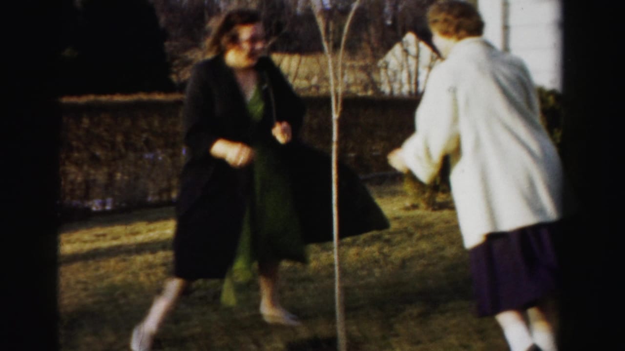 Two young women in mid-1950s coats and full skirts playfully square off in a suburban backyard, Albany, New York, circa 1955.