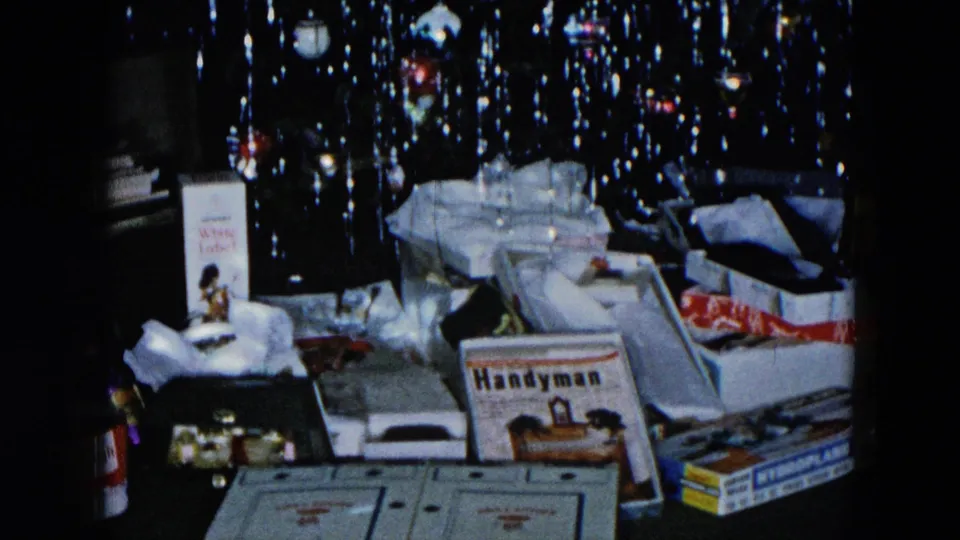1956 Hicksville NY 8mm home movie: Christmas gift pile with legible Handyman magazine, tissue paper, and boxes under an icicle-tinsel tree