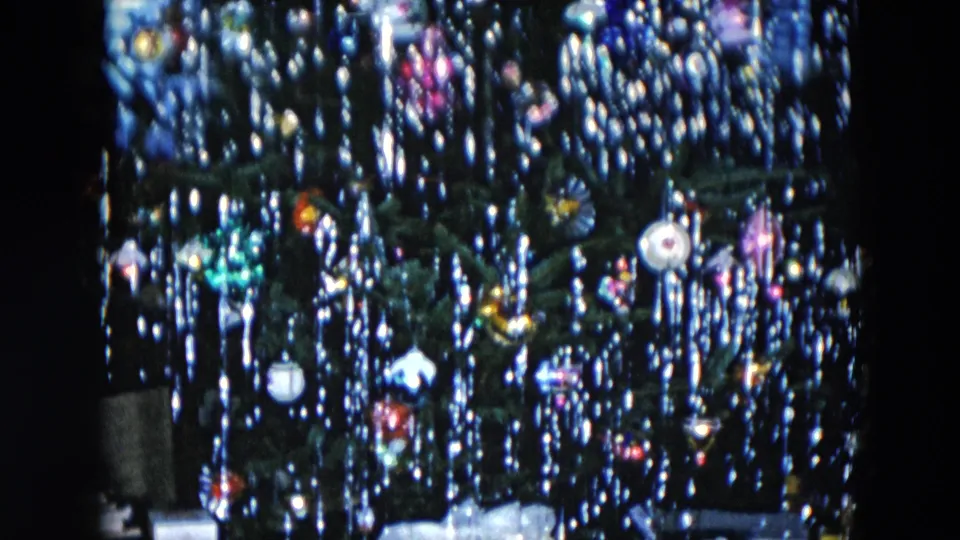 1956 Hicksville NY 8mm home movie: Christmas tree with multicolored glass ball ornaments and silver icicle tinsel in a dark domestic interior