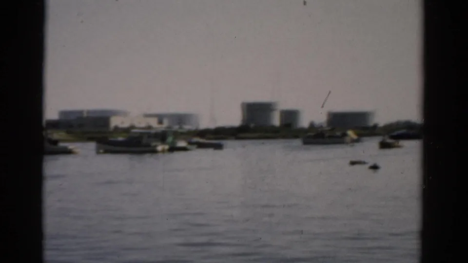Catskill, New York waterway, c.1957 — moored boats and industrial tank farm on far bank as camera shifts right, 8mm home movie.