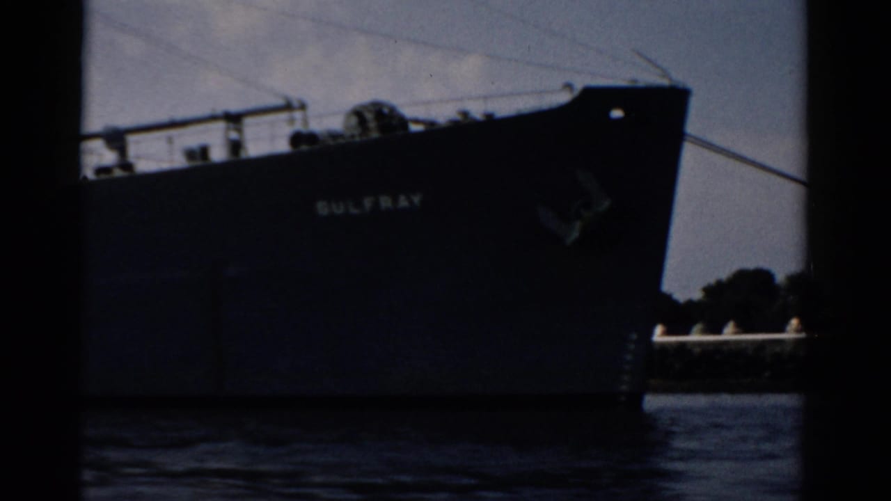 Close shot of cargo vessel 'GULFRAY' bow on calm water, circa 1957, possibly near Catskill, New York, shot on 8mm film.