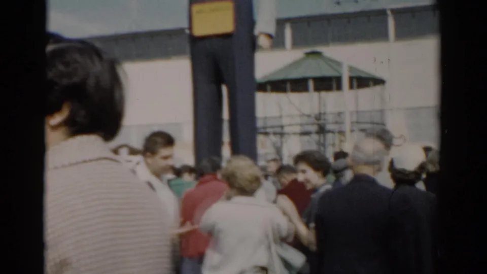 Visitors in 1950s casual attire crowd the fairground with the oversized figure and green gazebo structure behind, Catskill, New York, circa 1957.