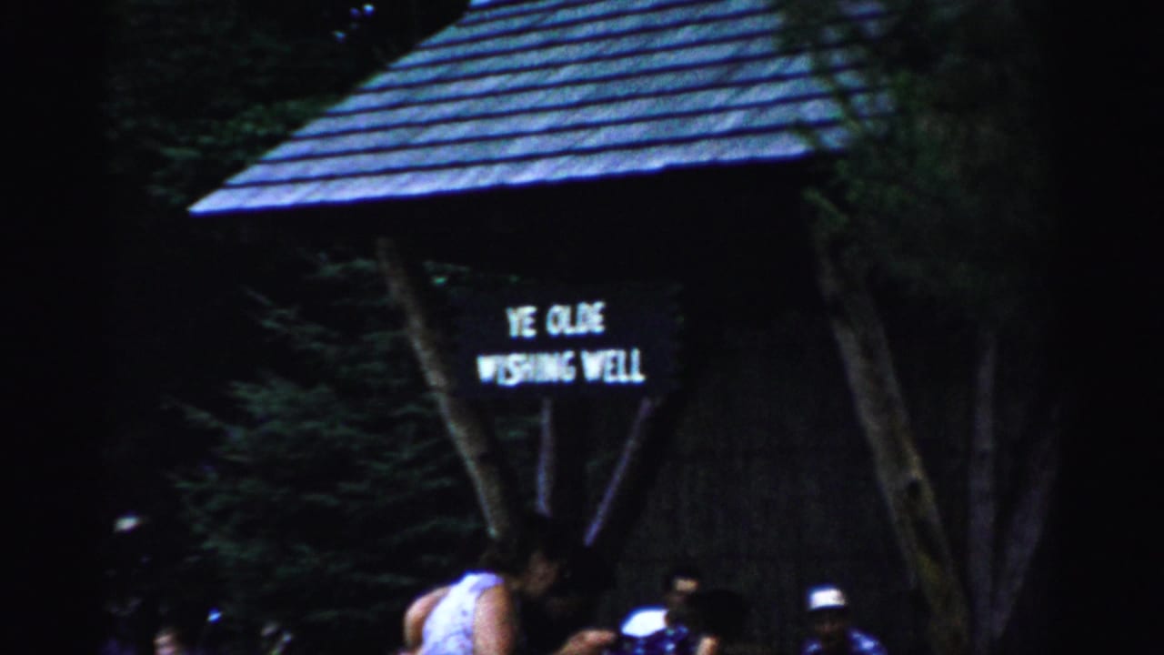 1957 Catskill footage shows the Ye Olde Wishing Well sign on a rustic wooden structure with visitors gathered beneath it.