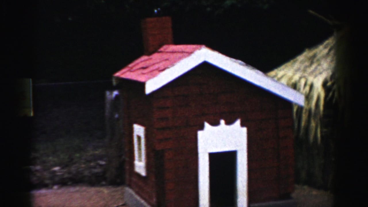 Miniature brick-style house with red peaked roof, chimney, and white-trimmed door at Three Little Pigs themed attraction, Catskill, New York, circa 1957