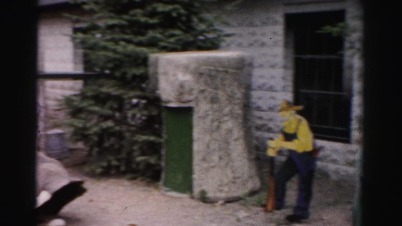 Man in yellow shirt and wide-brimmed hat at stone enclosure building, Catskill area, New York, circa 1957, 8mm home movie footage.