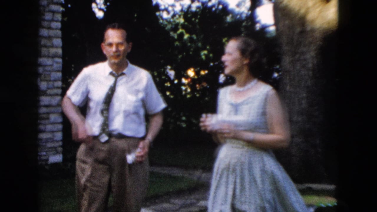 Man in late-1950s dress shirt and tie with a woman in a full-skirted light dress at what appears to be a backyard gathering, circa 1958.
