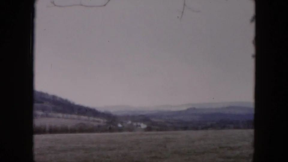 1957 8mm landscape view from metadata showing open fields near Hicksville with low hills or distant mountains on the horizon.