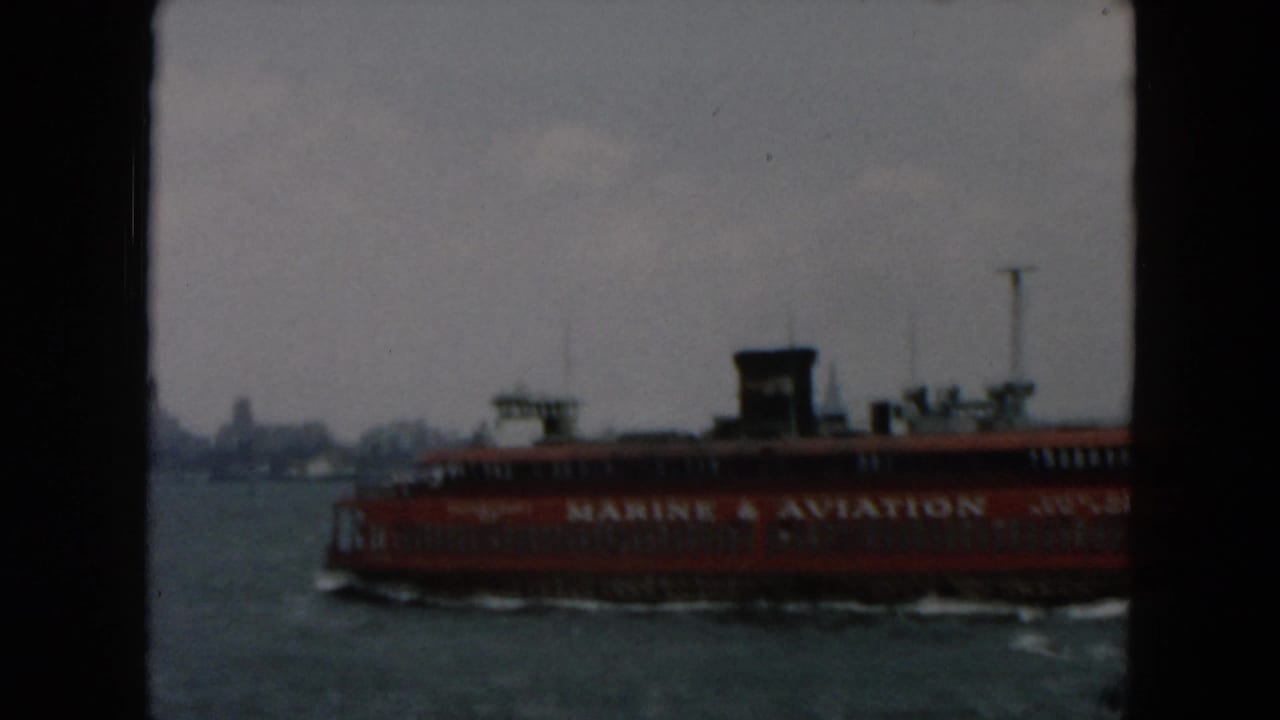 Red ferry crossing choppy harbor water with dark 8mm frame borders.