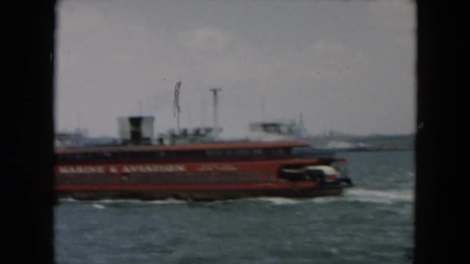 Red Staten Island Ferry with Marine & Aviation lettering appears on a misty New York harbor waterway.
