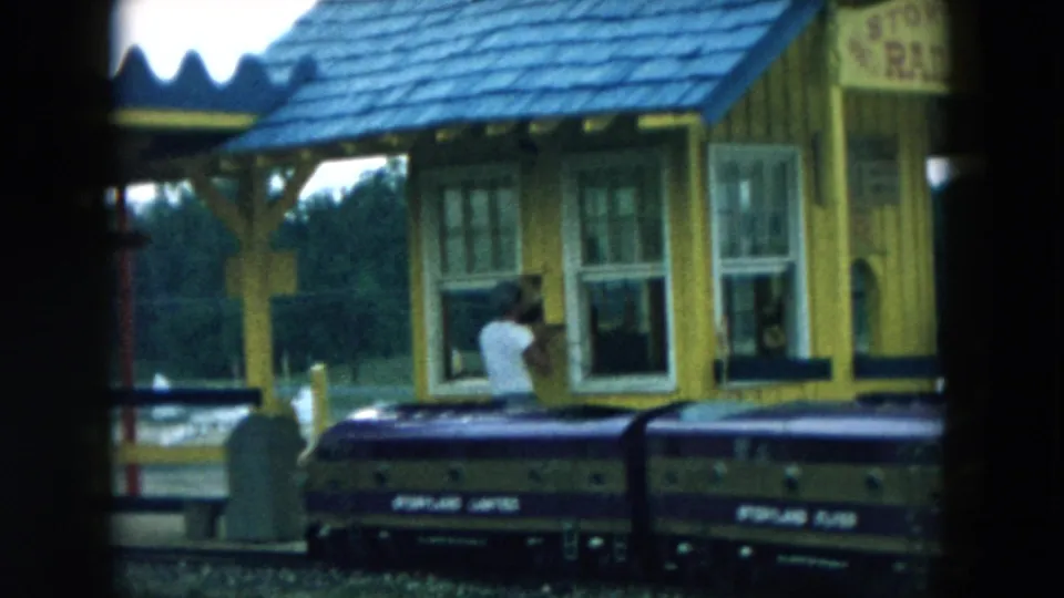 1957 Hicksville park footage showing a yellow Storyland station and miniature train cars passing in the foreground.