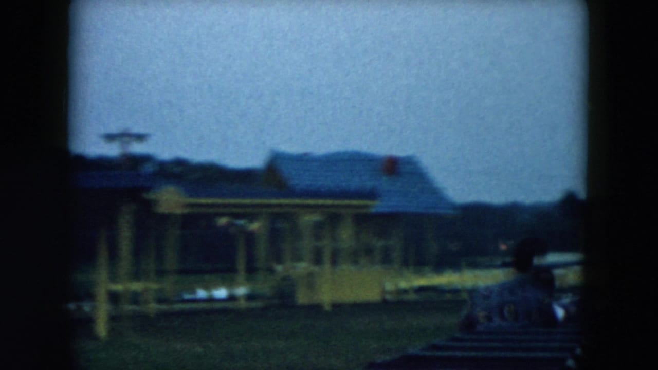 Blurred amusement-park station and ride structure seen from moving seats.