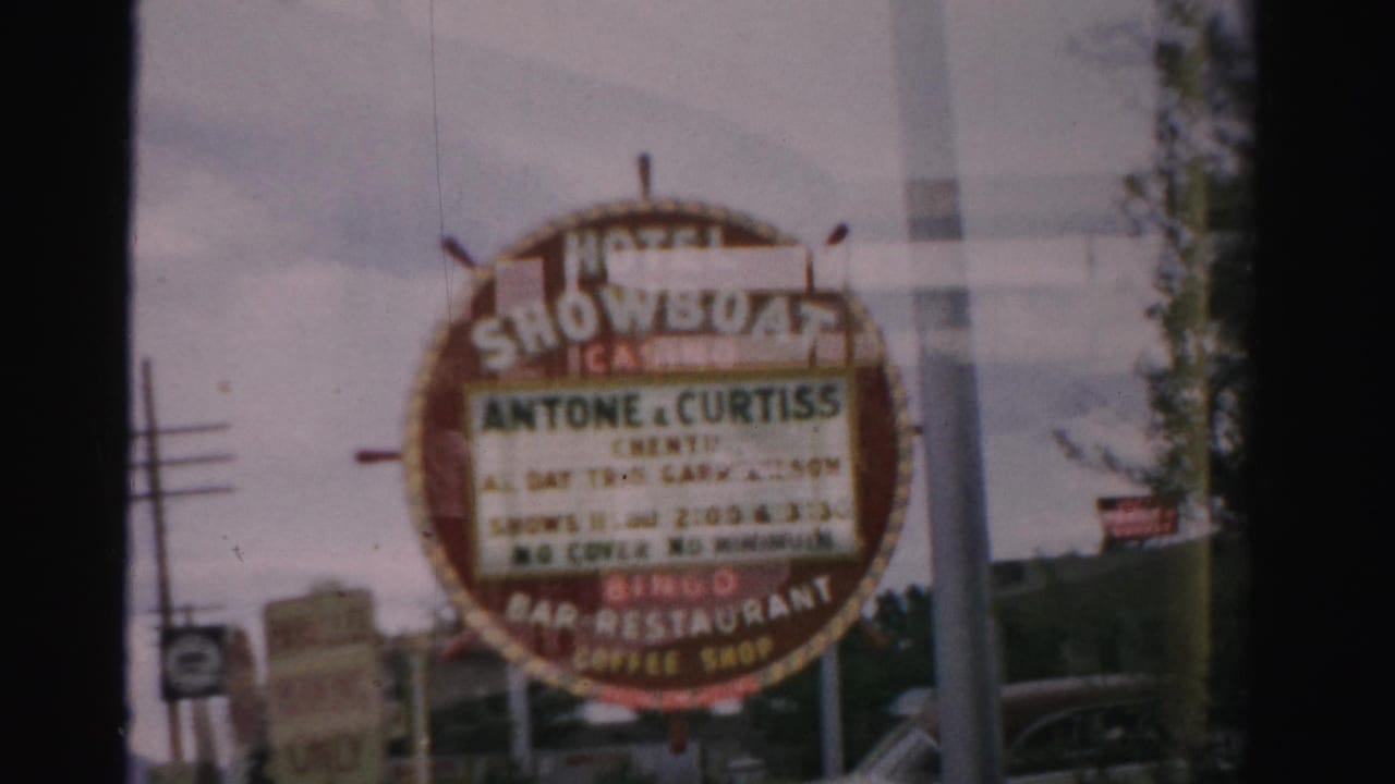 Circular Hotel Showboat Casino sign framed by dark window mullions and roadside poles.