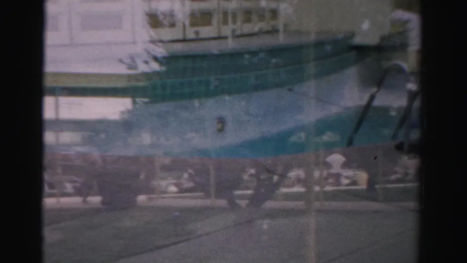 1957 Las Vegas home-movie frame showing a resort pool area with a pool-closed sign, metal ladder, deck, and distant lounge chairs.