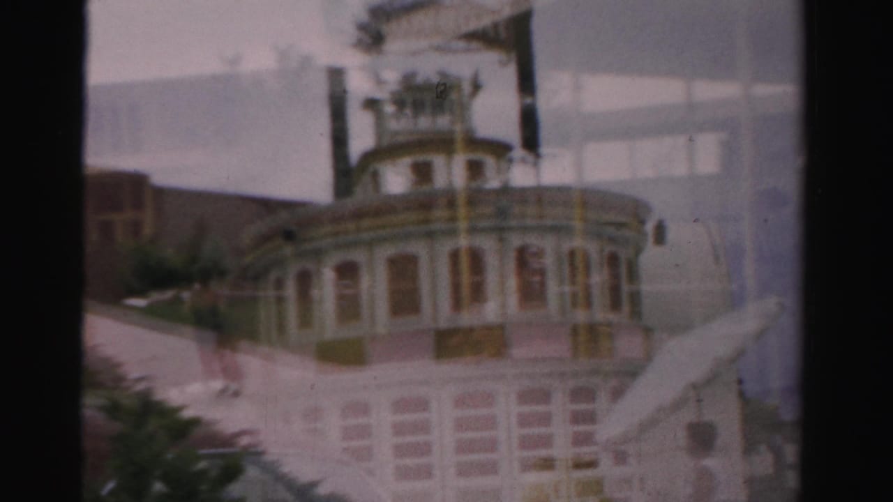 Soft cross-faded view of a riverboat-like building facade with exterior stairs and dark film borders.