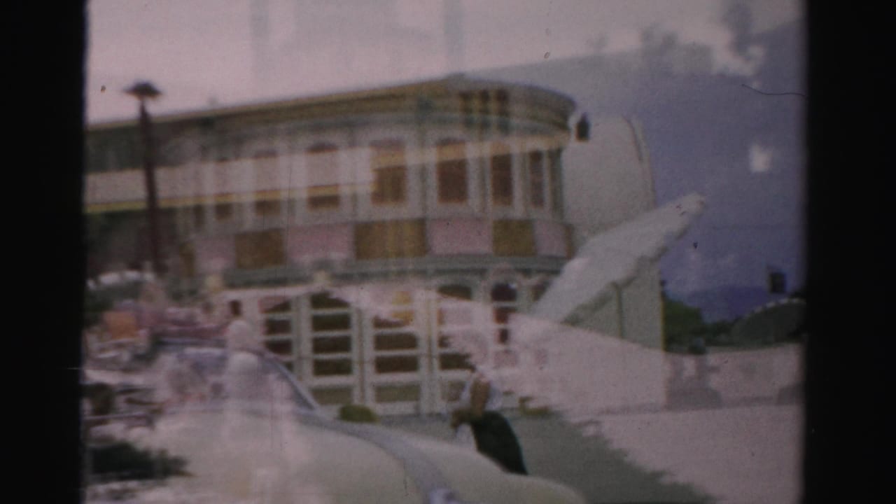 Riverboat-like facade and stairs overlaid with a poolside scene and small distant figures.