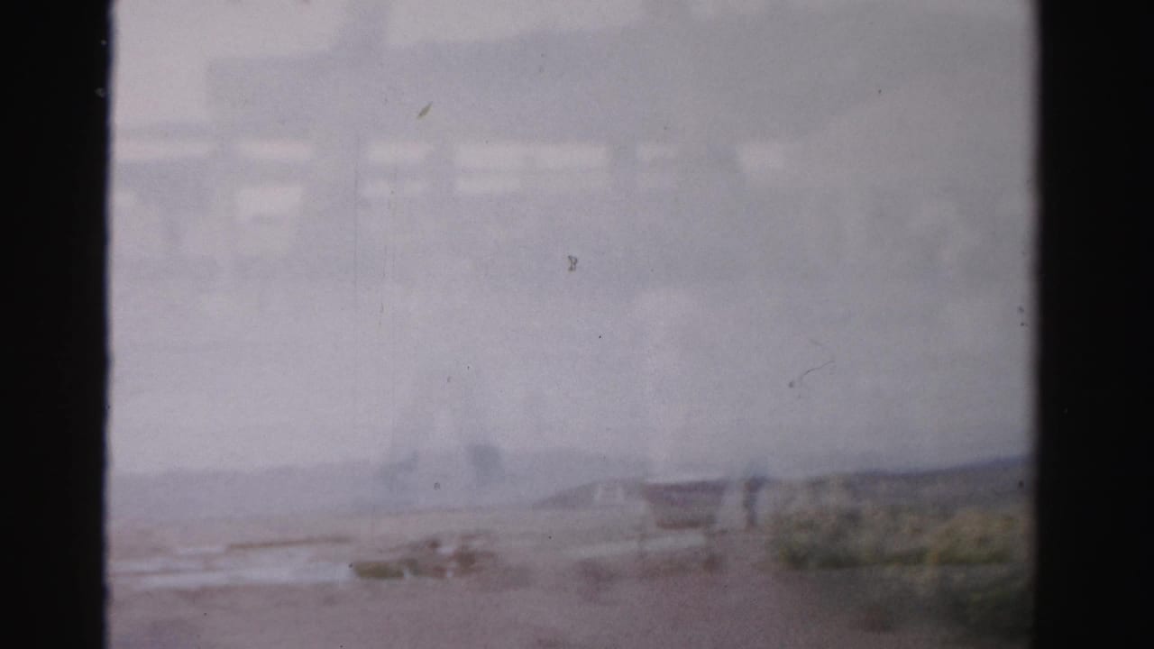 Soft, hazy view of an outdoor walkway and patio area with distant figures.