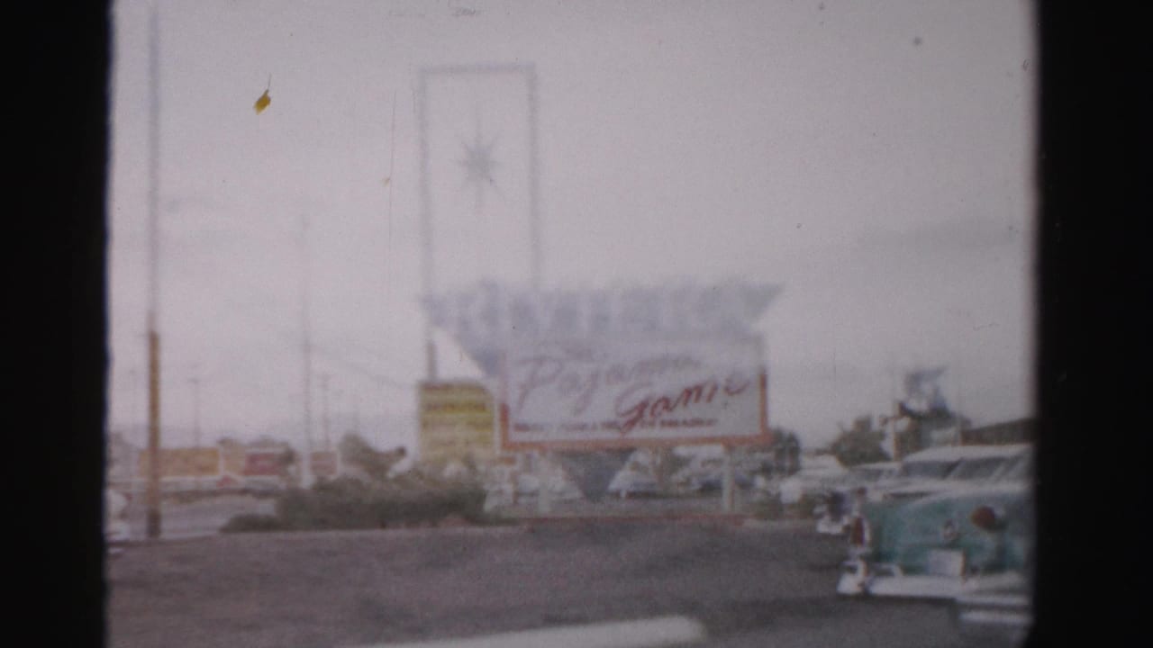 Riviera and Pajama Game signage with classic cars parked along the roadside.