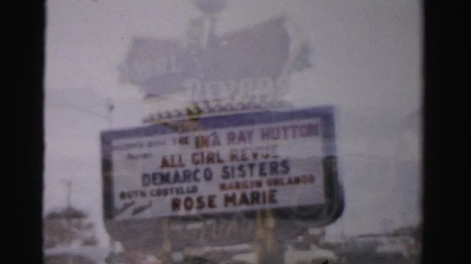1957 Las Vegas frame centered on the Royal Nevada marquee, with entertainment billing visible through soft 8mm focus.