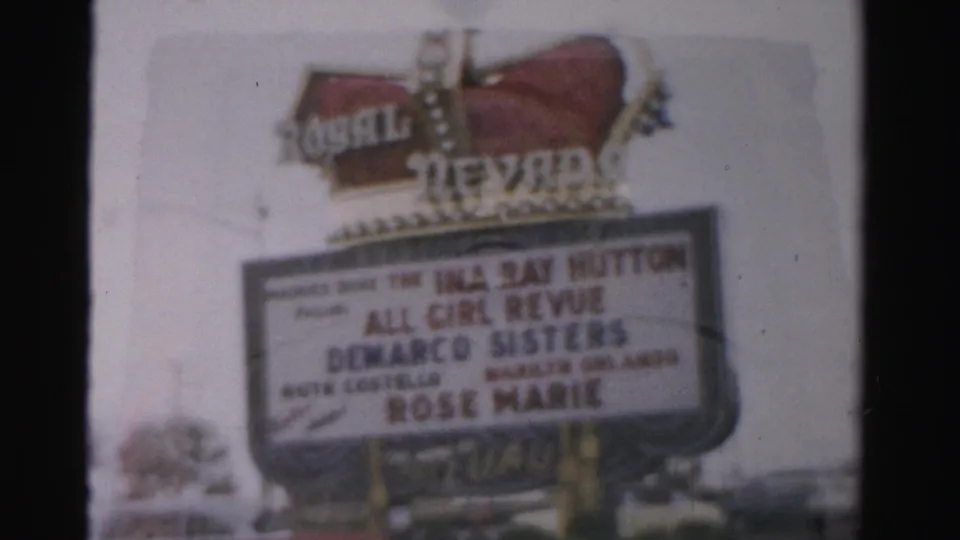 Soft 8mm close-up of the Royal Nevada hotel sign in Las Vegas, with marquee text for an all-girl revue visible.