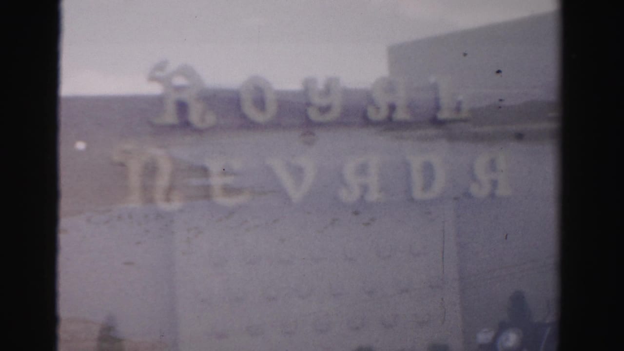 1957 Las Vegas home-movie frame showing blurred Royal Nevada lettering across a pale exterior facade.