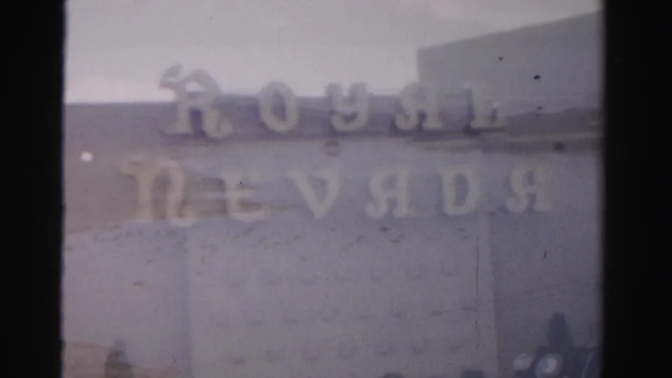 1957 Las Vegas home-movie frame showing blurred Royal Nevada lettering across a pale exterior facade.