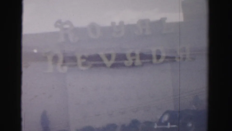 1957 Las Vegas frame showing the Royal Nevada sign area with dark foreground details and aged 8mm texture.