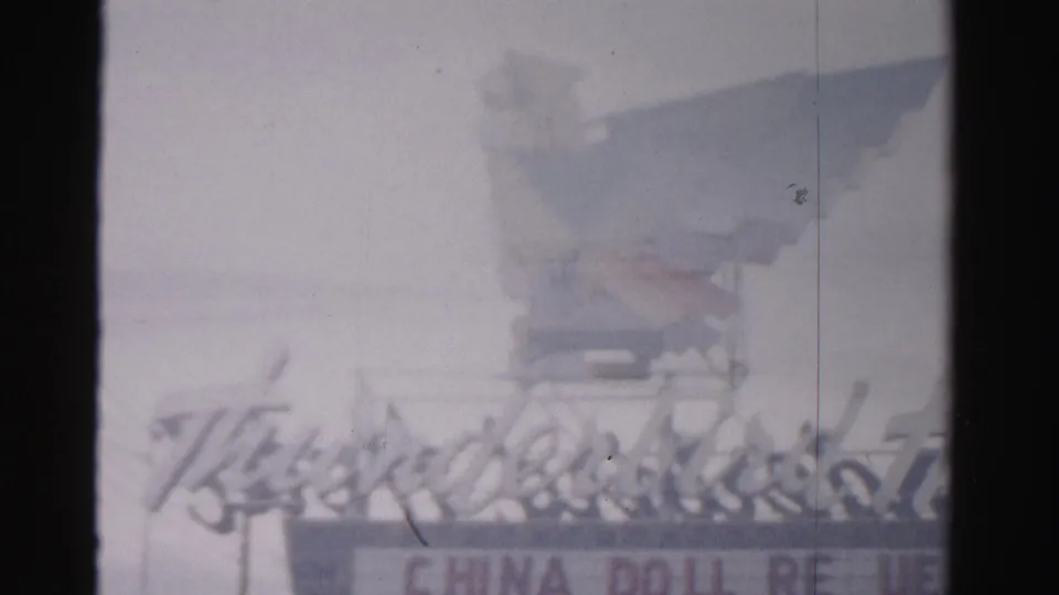 1957 Las Vegas home-movie view of the Thunderbird Hotel sign, with China Doll lettering softened by exposure and film wear.
