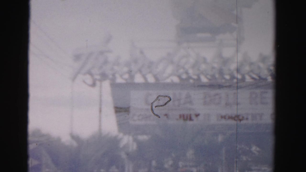 1957 Las Vegas frame showing the Thunderbird Hotel sign and eagle-like top sculpture, partly obscured by a dark film strip edge.