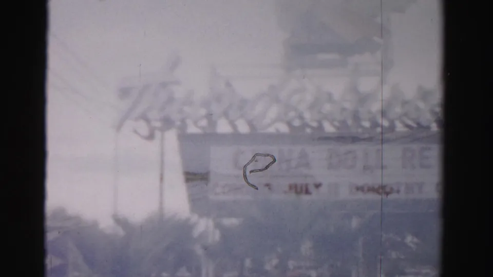 1957 Las Vegas frame showing the Thunderbird Hotel sign and eagle-like top sculpture, partly obscured by a dark film strip edge.