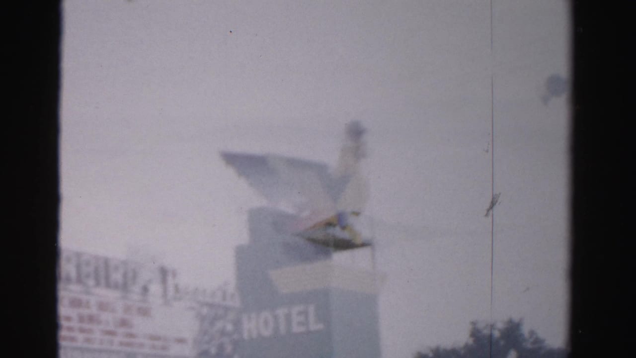 Hotel sign with large HOTEL lettering and a bird figure perched above it.