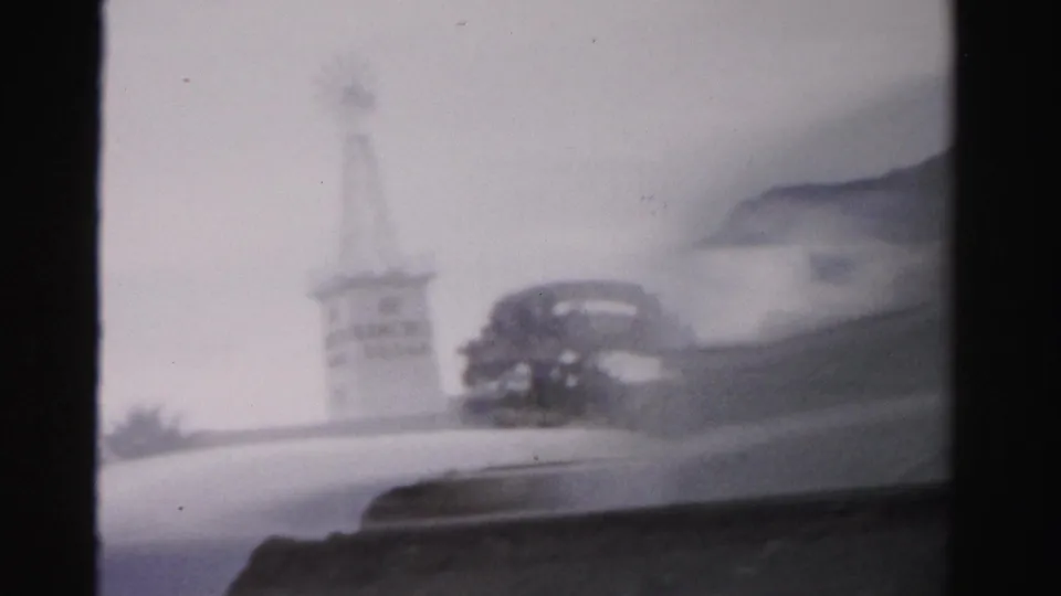 1957 Las Vegas frame with the tower and dark roadside feature partly obscured by a blurred foreground shape.