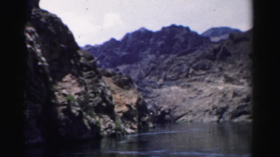 Rugged Nevada canyon walls and reservoir water fill the frame in a faded 1957 8mm travel view.