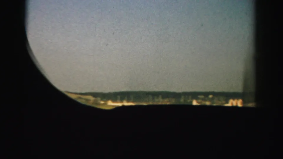 1957 Nevada airplane-window shot with distant airliners along the lower edge, open sky, and dark interior framing.