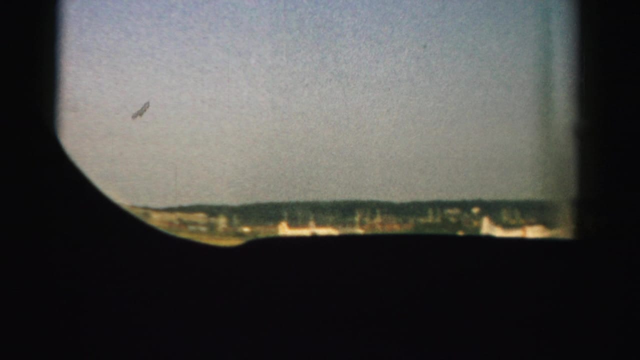 Pale sky over a distant horizon, with dark framing around the view.
