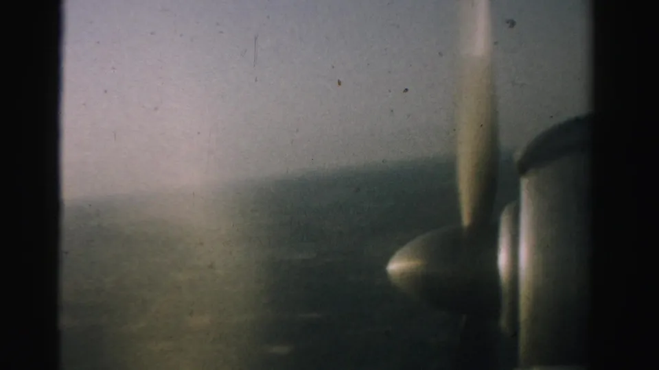Final 1957 Nevada 8mm frame with the small aircraft engine and propeller silhouetted against hazy ground below.