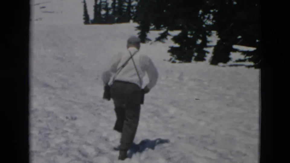 Adult man in a light shirt and suspenders walks away across a snowy Oregon mountain slope, based on supplied metadata.