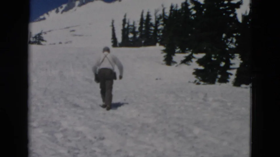Final frame shows the man farther uphill in the snowy Oregon mountain scene, with trees and film-edge borders visible.