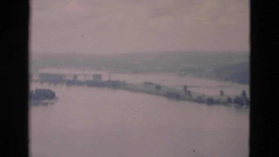 The final frame shows the lake stretching toward a distant tree-lined shore and low hills, bordered by the 8mm scan frame.