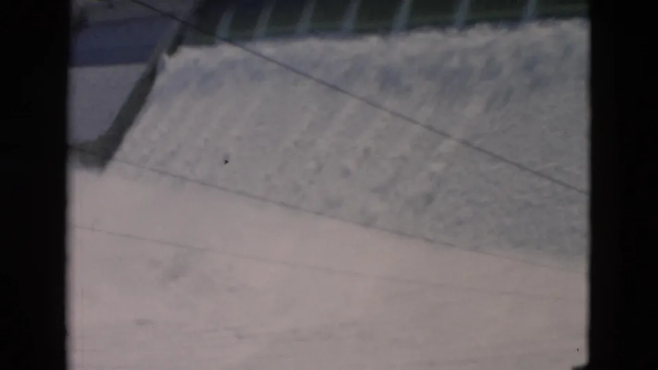 1958 Montana 8mm frame emphasizing turbulent water moving down the concrete dam spillway.
