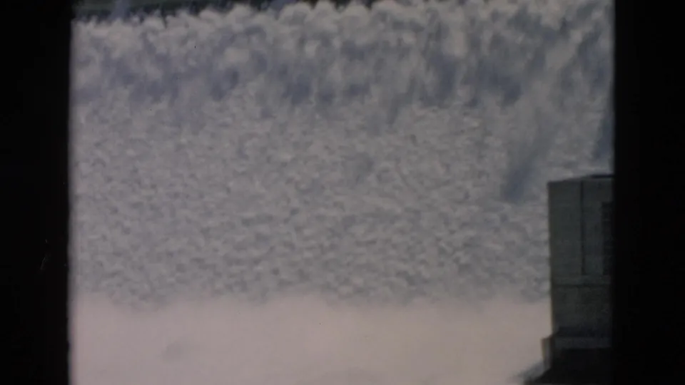 1958 Montana footage showing foaming water below a dam spillway, with concrete structure at the edge of frame.