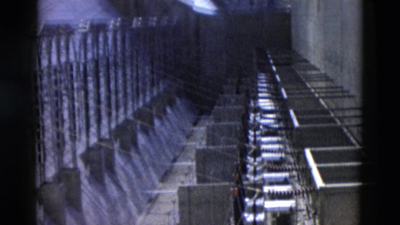Interior dam structure with rows of supports, railings, and machinery areas.