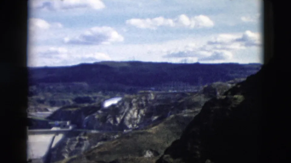 1958 Montana home-movie view looking across the dam area toward hills and a rocky foreground from an elevated overlook.