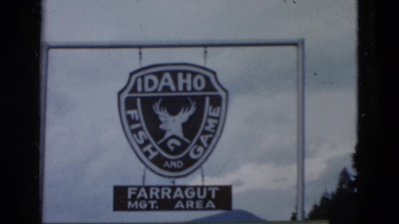 1958 8mm frame showing an Idaho Fish and Game shield sign with Farragut management-area text below it.