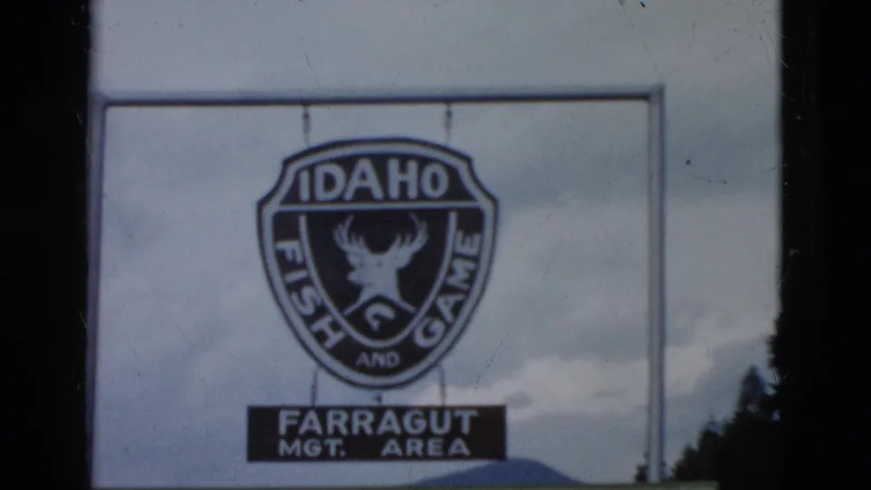 1958 8mm frame showing an Idaho Fish and Game shield sign with Farragut management-area text below it.