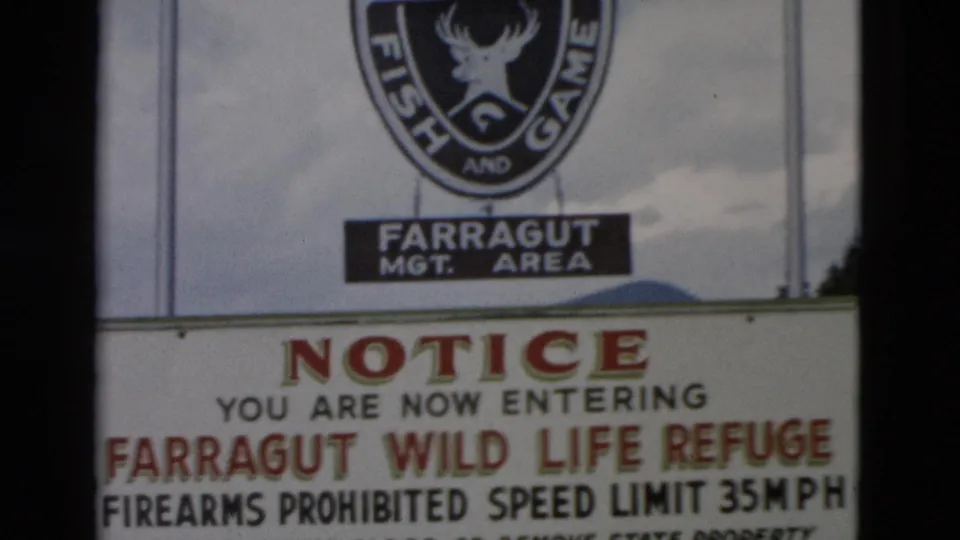 The frame shows the Idaho Fish and Game sign and a notice for Farragut Wild Life Refuge, including firearms and speed-limit wording.
