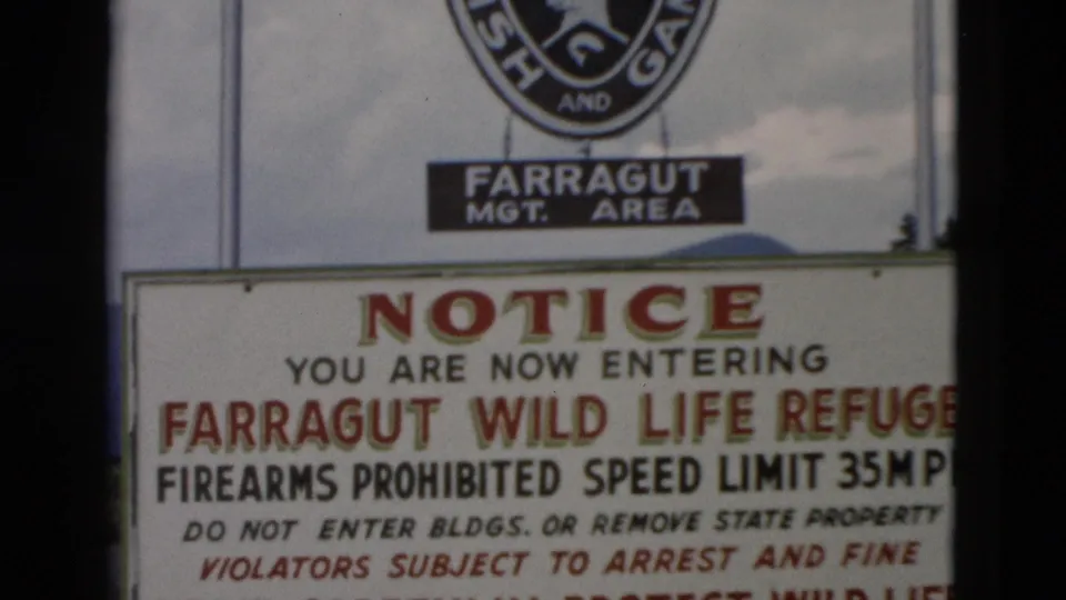1958 8mm frame showing the Farragut Wild Life Refuge notice, including firearms prohibited, 35 mph speed limit, and arrest warning text.
