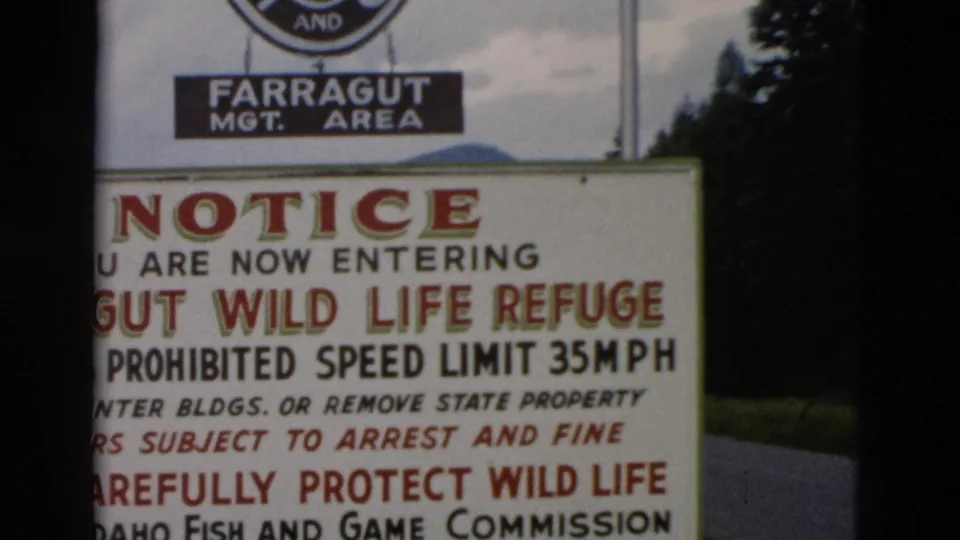 1958 8mm frame showing a cropped close-up of the Farragut Wild Life Refuge notice and Idaho Fish and Game Commission line.